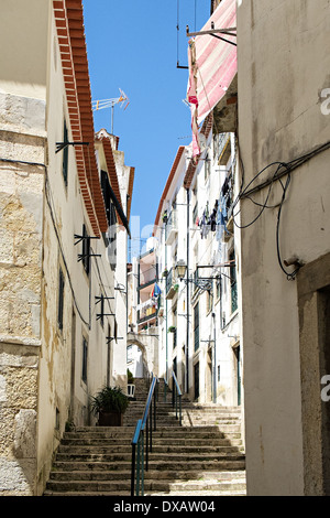 Stretto vicoletto con appeso il lavaggio esterno appartamenti in Alfama, Lisbona Foto Stock