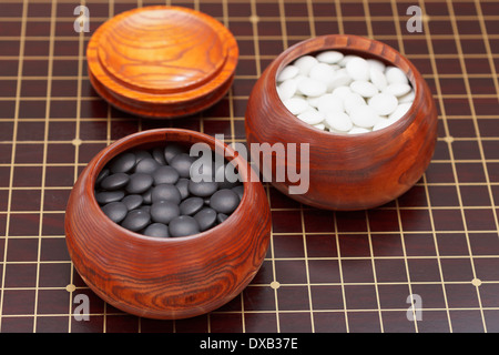 Bianco e nero gioco go pietre in ciotola di legno Foto Stock