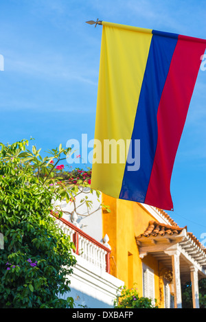 Vista della bandiera colombiana con architettura coloniale e cielo blu a Cartagena, Colombia Foto Stock