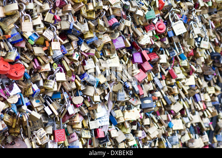 Amore desiderio serrature serrature sinistra come cimeli da turista un gran numero di amore lucchetti adornano uno di Parigi famosi ponti Foto Stock