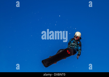 Snowboarder che viaggiano attraverso l'aria Foto Stock