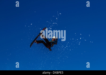 Snowboarder che viaggiano attraverso l'aria Foto Stock