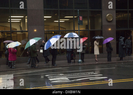 La gente in attesa per un autobus pubblico esterno alla Grand Central Station su un pomeriggio piovoso in NYC. Foto Stock