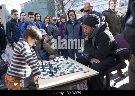 Giovane prodigio giocatore di scacchi assume i grandi ragazzi di Union Square Park, New York. Foto Stock