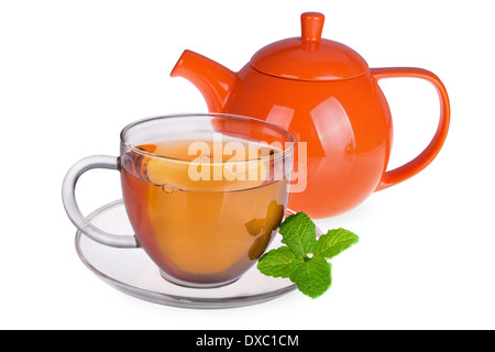 Bicchiere di vetro di tè con foglie di menta e teiera arancio isolato su sfondo bianco Foto Stock