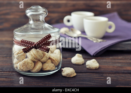 Biscotti Freschi in un vasetto di vetro con caffè su sfondo di legno Foto Stock