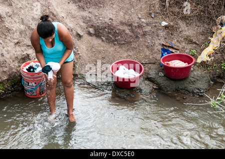 Donna Peruviana a lavare i panni nel fiume.piura, Perù. Foto Stock