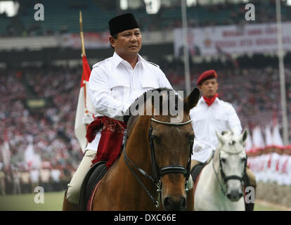 Centro di Jakarta, Jakarta, Indonesia. 23 Mar, 2014. PRABOWO SUBIANTO (al centro), il candidato presidenziale per il grande movimento di Indonesia o Gerindra, sfilate a cavallo come egli ispeziona un appello dei sostenitori come frequenta una campagna raccolta nella prospettiva delle elezioni legislative in Gelora Bung Karmo Staduim. PRABOWO SUBIANTO, ex comandante di Indonesia di forze speciali o Kopassus, è il principale rivale per il popolare governatore di Jakarta, Joko Widodo, chi è in esecuzione anche per il presidente del paese le elezioni presidenziali del 9 luglio che seguirà un voto legislativo il 9 aprile. (Cre Foto Stock