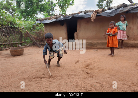 Tribal i bambini giocando gulli-danda nel cortile di una casa. Malhar casta bambini. District Hazaribaug, nello stato del Jharkhand Foto Stock