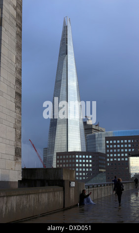 Poveri accattonaggio vicino al London's edificio, Shard evidenziando le differenze di ricchezza di questo mondo. Ingiusto Nuovo Ordine Mondiale. Foto Stock