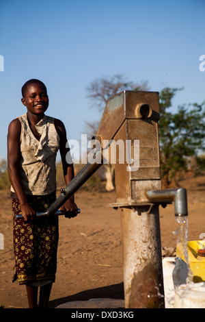 Africa bambino raccolta di acqua in un tubo di supporto Foto Stock