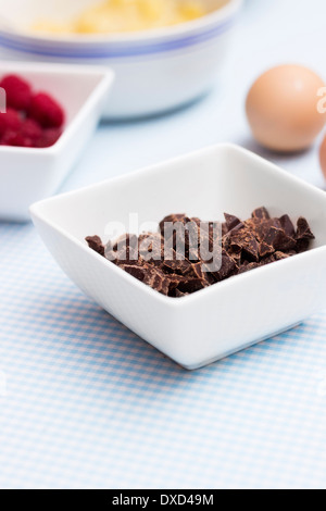 Primo piano di cioccolato su un tavolo da cucina con altri ingredienti alimentari per rendere organico torta paleo Foto Stock