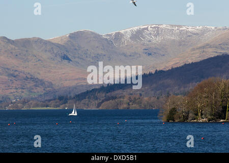 Lago di Windermere, Cumbria, Regno Unito. Il 24 marzo 2014. Cielo blu e una giornata di sole fornire un contrasto all'ultima neve sulle alte brughiere a nord del lago come un prestito in barca a vela fa il suo modo attraverso Windermere. Credito: Gordon Shoosmith/Alamy Live News Foto Stock