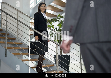 Imprenditore a piedi fino a imprenditrice su scala Foto Stock