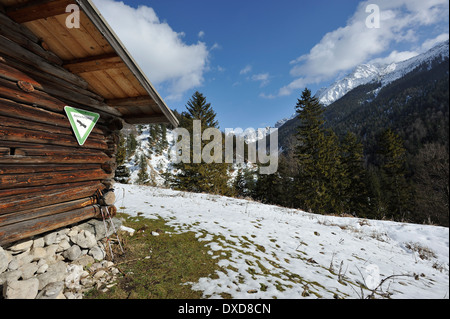 Rifugio di montagna con riserva naturale segno e pali trekking, Ochsenalm in presenza di neve sul Karwendel mountain range, Baviera, Germania Foto Stock