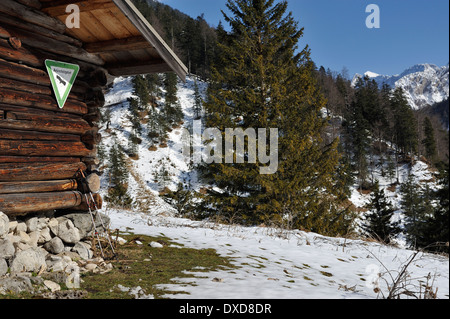 Rifugio di montagna con riserva naturale segno e pali trekking, Ochsenalm in presenza di neve la regione alpina, Baviera, Germania Foto Stock