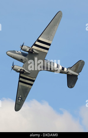 Douglas C-47 Skytrain in marcature mimetiche del periodo, tra cui le "strisce di invasione" del D Day. Aereo da trasporto della seconda guerra mondiale in volo all'aerodromo Foto Stock