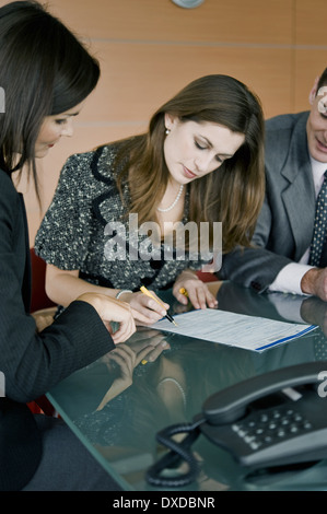 Giovane donna firma documento, donna professionale rivolta Foto Stock