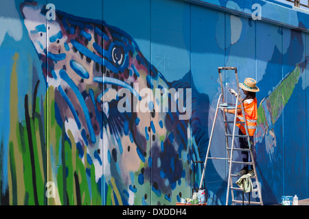 Gli studenti di arte pittura di un murale sulla parete del porto di Los Cristianos Tenerife Isole Canarie Spagna Foto Stock