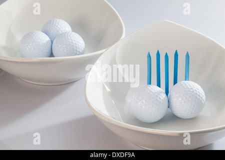 Due ceramiche bianche bocce e palline da golf Foto Stock