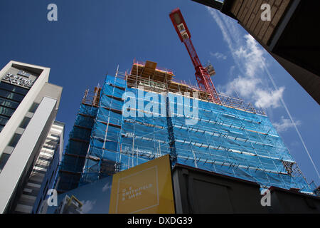 Cantiere Hi-Rise, builders Security impalcatura rete a Manchester marzo, 2014. La gru da cantiere Tower HTC presso One Smithfield Square, consegnata da Muse Developments, comprenderà 77 appartamenti con una, due e tre camere da letto e più di 6,000 piedi quadrati di spazio commerciale al piano terra Foto Stock