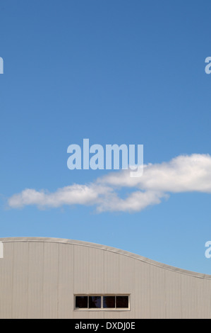 Close-up del tetto della costruzione in metallo con finestra e il cielo blu con nuvole Foto Stock