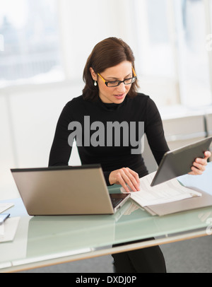 Imprenditrice lavorando su laptop e tablet digitale Foto Stock