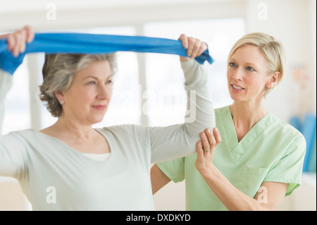 Donna matura esercitando con personal trainer Foto Stock