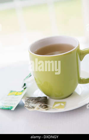 Utilizzate un sacchetto da tè sul piattino con tazza di tè nella tazza verde, Studio Shot Foto Stock