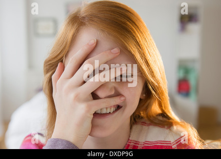 Vista frontale della ragazza (12-13) con la mano sulla testa Foto Stock