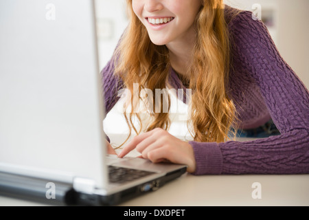 La ragazza (12-13) utilizzando laptop, metà sezione Foto Stock