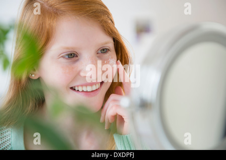 La ragazza (12-13) l'applicazione di crema idratante Foto Stock