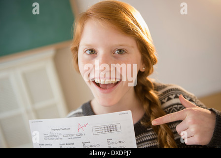 Ritratto di ragazza (12-13) che mostra un foglio di esame Foto Stock