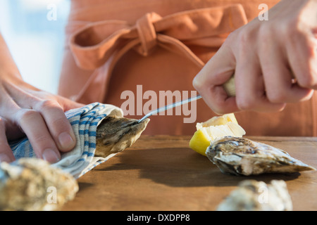 Donna shucking ostriche Foto Stock