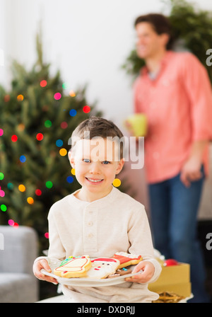 Ragazzo (6-7) tenendo la piastra con pan di zenzero Foto Stock