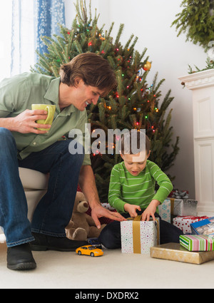 Padre e figlio (6-7) apertura regali di Natale Foto Stock