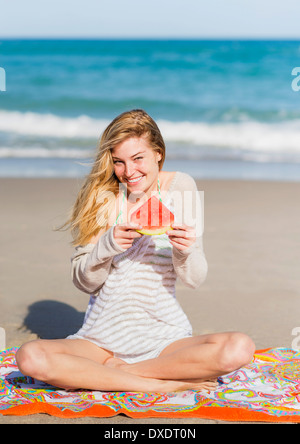 Giovane donna sulla spiaggia mangiando anguria, Jupiter, Florida, Stati Uniti d'America Foto Stock