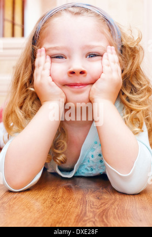 Felice bambina giacente sul pavimento Foto Stock