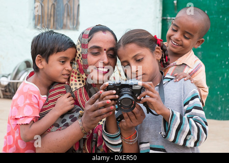 India, Uttar Pradesh, Agra, madre e tre bambini guardando il retro di una moderna fotocamera digitale Foto Stock