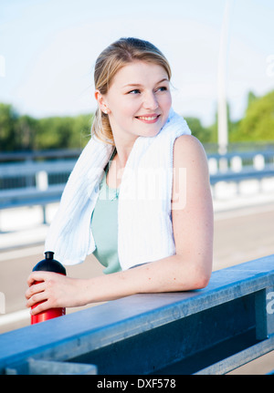 Giovane donna con asciugamani e acqua in bottiglia, Worm, Renania-Palatinato, Germania Foto Stock