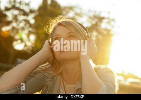 Giovane donna l'ascolto di musica con cuffie, Mannehim, Baden-Württemberg, Germania Foto Stock