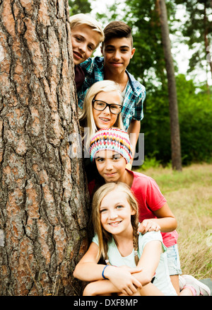 Ritratto di gruppo di bambini in posa vicino ad albero nel parco, Germania Foto Stock