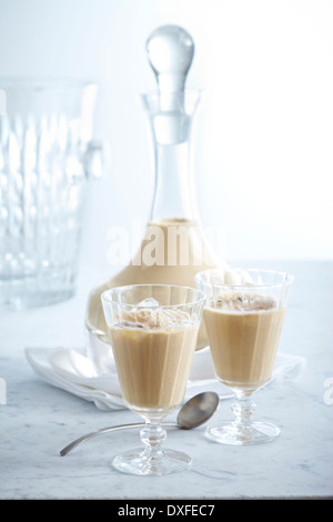 Decanter e bicchieri riempiti con crema di liquore, studio shot Foto Stock