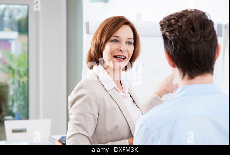 Imprenditrice che spiega il lavoro di apprendista in ufficio, Germania Foto Stock