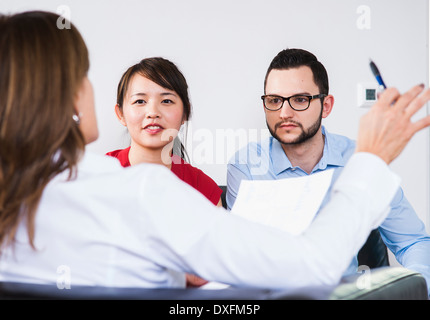 Backview di imprenditrice in discussione con coppia giovane, Germania Foto Stock