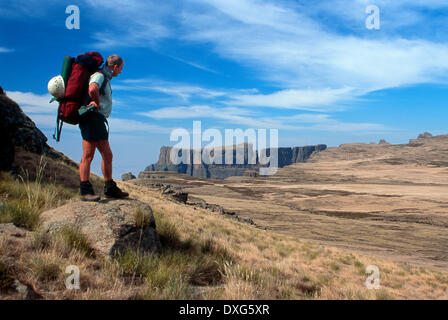 Escursionista sulla scarpata sopra l'Anfiteatro conla contrafforte orientale e del diavolo dietro a dente, Drakensberg Foto Stock