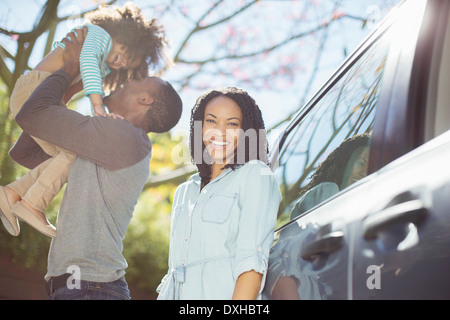 Ritratto di donna felice con mio marito e mia figlia fuori dall'auto Foto Stock