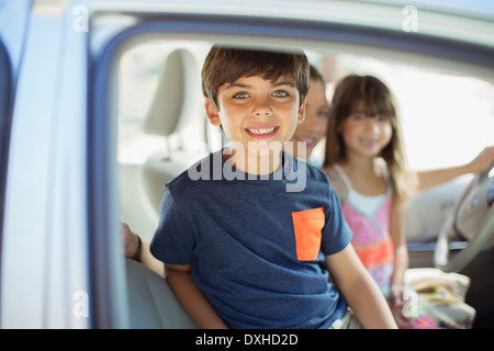 Ritratto di ragazzo sorridente all'interno dell'auto Foto Stock