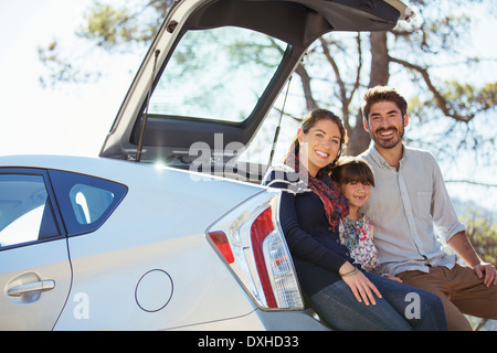 Ritratto di famiglia felice in corrispondenza della parte posteriore della macchina Foto Stock