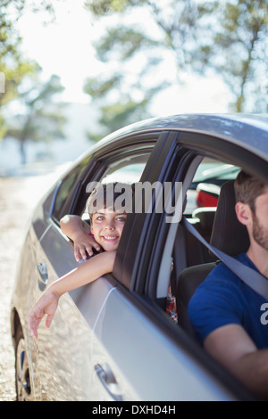 Ritratto di ragazzo sorridente sporgersi finestra auto Foto Stock